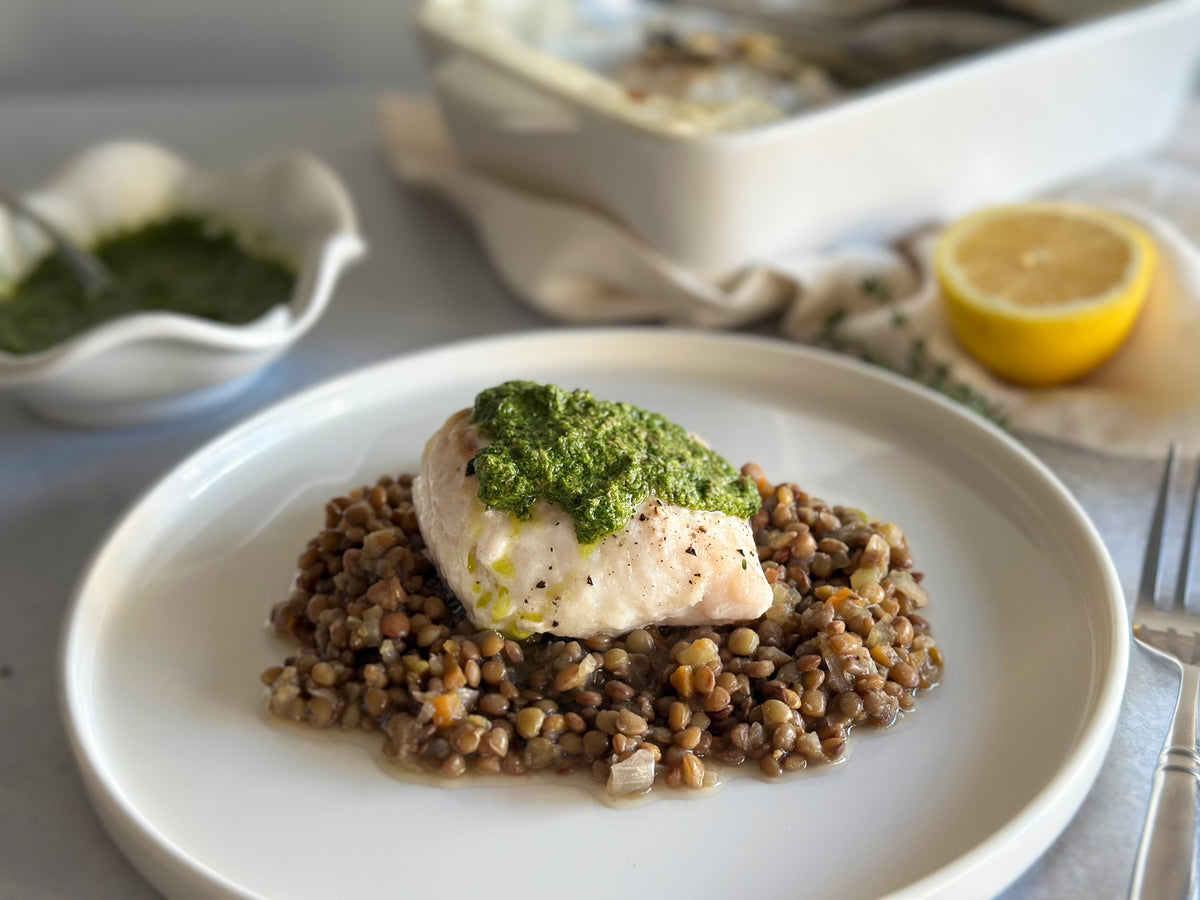 Baked cod served on lentils with salsa verde